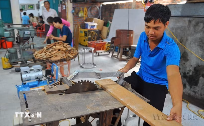 Người khuyết tật làm đồ gỗ tại một trung tâm dạy nghề phát triển việc làm và hỗ trợ người khuyết tật. (Ảnh: Minh Đức/TTXVN)