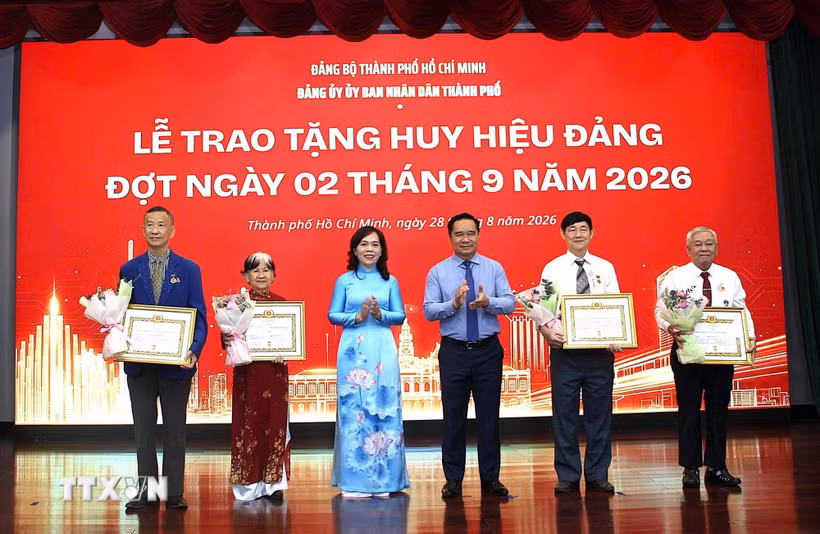 Trao Huy hiệu 45 năm tuổi Đảng cho các đảng viên. (Ảnh: Liên Sơn/TTXVN)