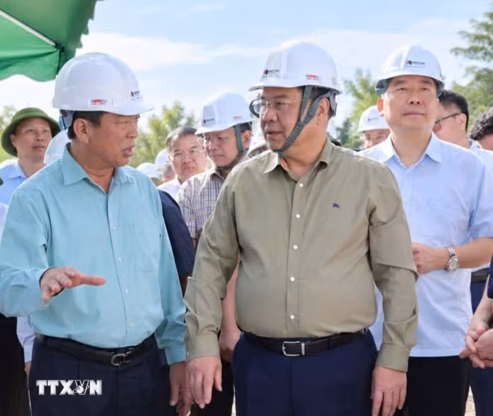 Phó Thủ tướng Thường trực Phạm Gia Túc nghe đại diện nhà thầu báo cáo tiến độ thi công tại công trường. (Ảnh: TTXVN phát)
