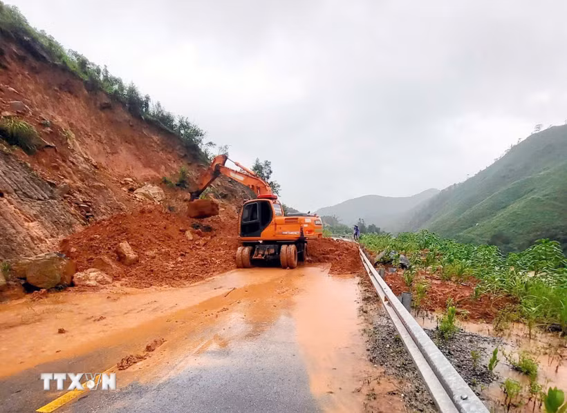 Lực lượng chức năng thu dọn đất đá sạt lở. (Ảnh: Phạm Lợi/TTXVN)