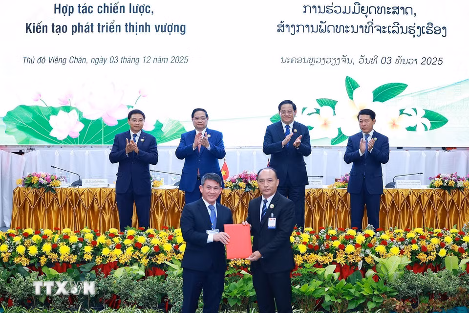 Thủ tướng Phạm Minh Chính và Thủ tướng Lào Sonexay Siphandone chứng kiến trao biên bản hợp tác giữa doanh nghiệp hai nước. (Ảnh: Dương Giang/TTXVN)