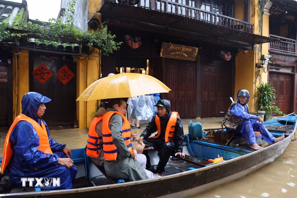 Lực lượng chức năng hỗ trợ du khách quốc tế tại Hội An di chuyển đến nơi an toàn. (Ảnh: Anh Dũng/TTXVN)
