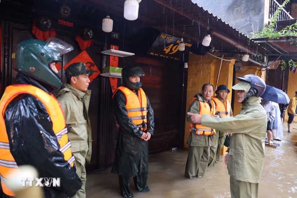Chủ tịch phường Hội An Nguyễn Tấn Cường (ngoài cùng bên phải) chỉ đạo lượng chức năng tăng cường ứng trực ở các vị trí xung yếu để hỗ trợ nhân dân. (Ảnh: Anh Dũng/TTXVN)