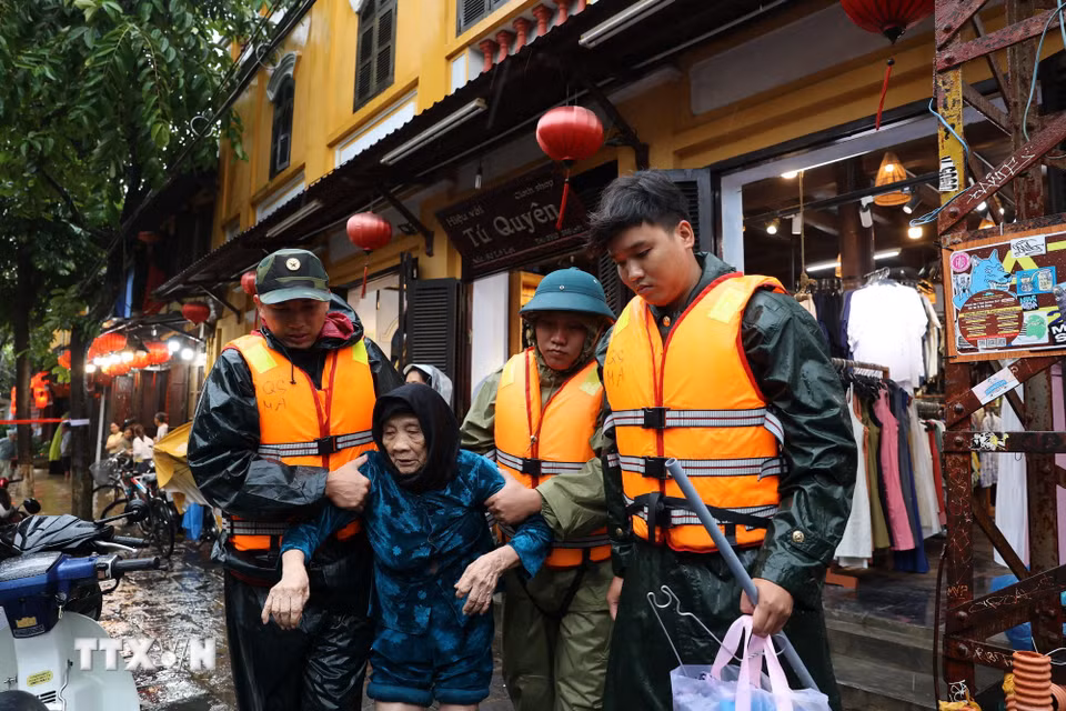 Lực lượng chức năng hỗ trợ người dân ở Hội An di chuyển đến nơi an toàn. (Ảnh: Anh Dũng/TTXVN)