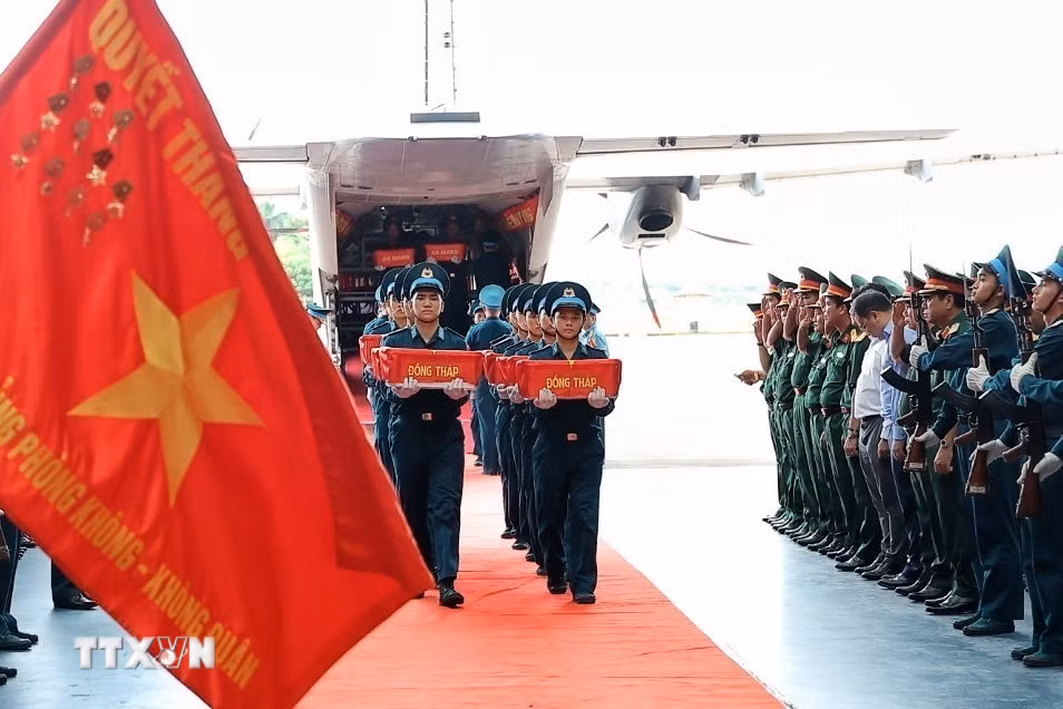 Các thùng chứa mẫu sinh phẩm hài cốt liệt sỹ được đưa từ máy bay vận tải quân sự xuống khu vực tiếp nhận tại sân bay quân sự Gia Lâm. (Ảnh: Phạm Tuấn Anh/TTXVN)