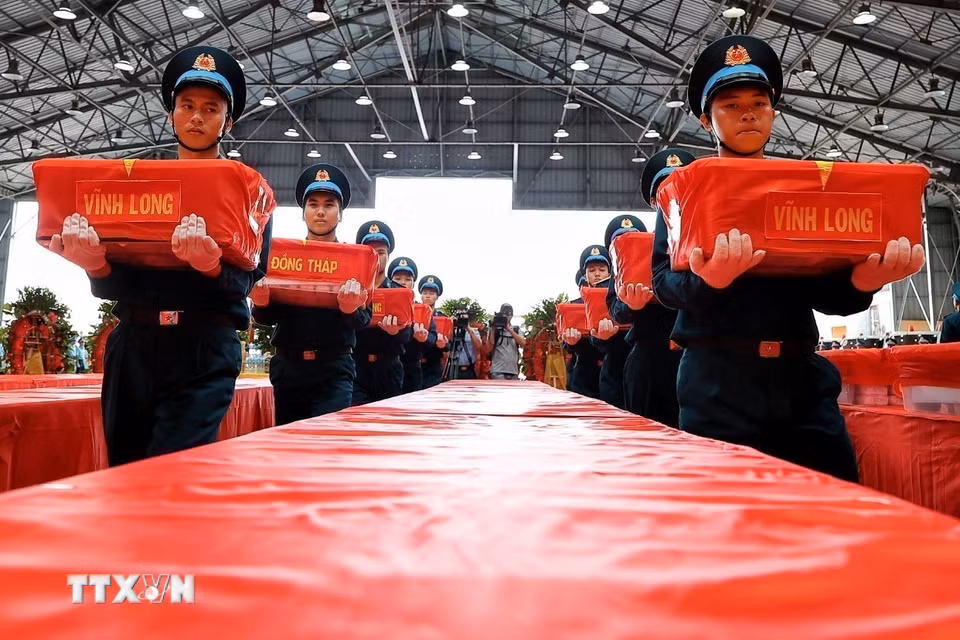 Cán bộ, chiến sỹ trang nghiêm thực hiện nghi thức tiếp nhận các thùng chứa mẫu sinh phẩm hài cốt liệt sỹ tại sân bay quân sự Gia Lâm. (Ảnh: Phạm Tuấn Anh/TTXVN)