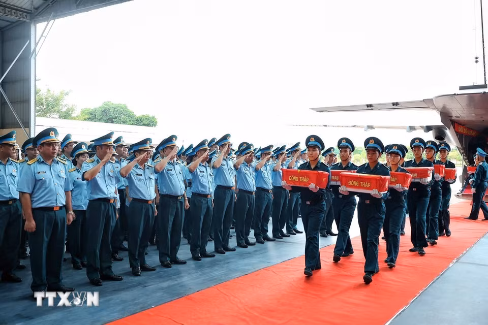 Cán bộ, chiến sỹ Quân chủng Phòng không - Không quân thực hiện nghi thức chào khi các mẫu sinh phẩm hài cốt liệt sỹ của các địa phương thuộc Quân khu 9 được đưa khỏi máy bay tại sân bay quân sự Gia Lâm. (Ảnh: Phạm Tuấn Anh/TTXVN)