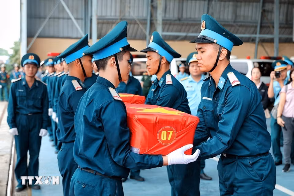 Cán bộ, chiến sỹ tiếp nhận các thùng chứa mẫu sinh phẩm hài cốt liệt sỹ sau khi được vận chuyển bằng máy bay quân sự từ Cần Thơ ra Hà Nội. (Ảnh: Phạm Tuấn Anh/TTXVN)