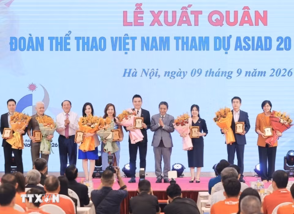 Ban tổ chức tặng hoa và bảng danh vị cho các đơn vị tài trợ. (Ảnh: Minh Quyết/TTXVN)