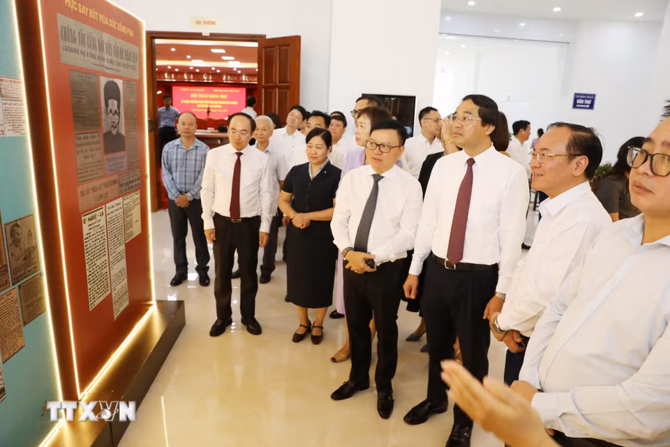 Đại biểu tìm hiểu thông tin về nhà chiến sỹ yêu nước Huỳnh Thúc Kháng tại khu trưng bày sự kiện. (Ảnh: Vũ Hoàng Giang/TTXVN)