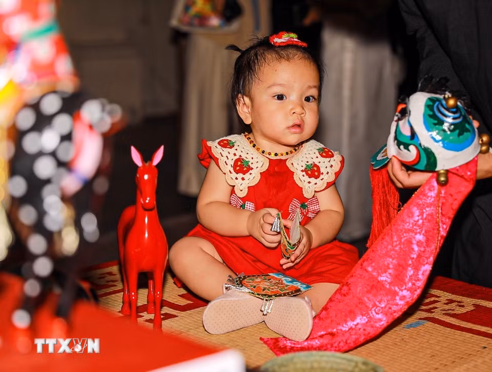 Em nhỏ thích thú với các món đồ chơi trung thu truyền thống.(Ảnh: Khánh Hòa/TTXVN)