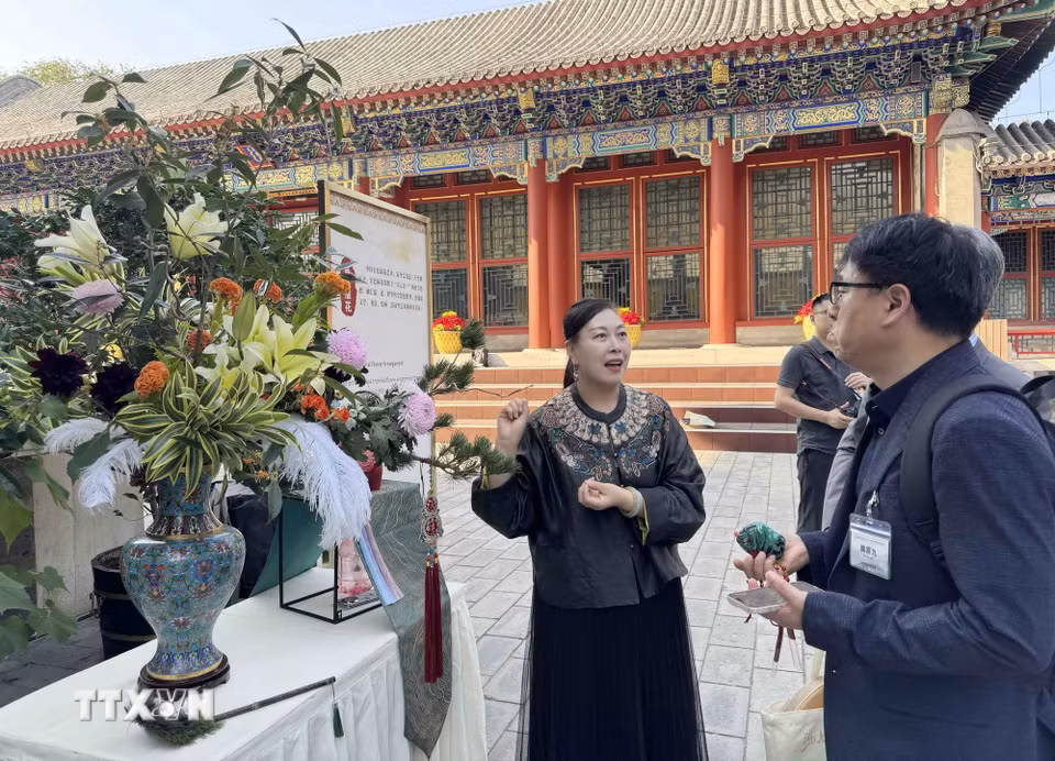 Các phóng viên, nhà báo nước ngoài tại Bắc Kinh tìm hiểu văn hóa cắm hoa của Trung Quốc. (Ảnh: Công Tuyên/TTXVN)
