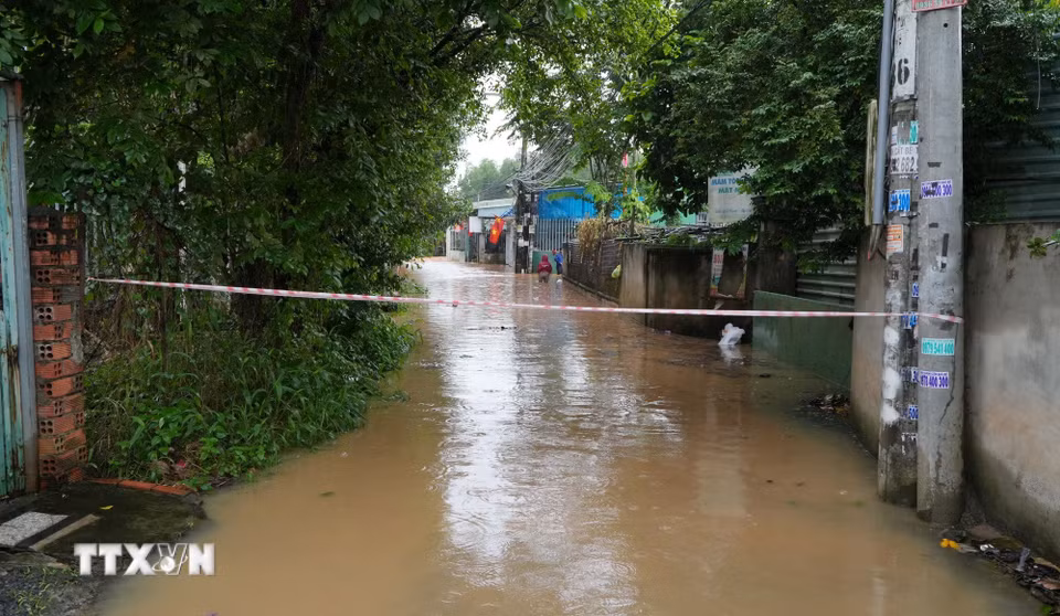 Lực lượng chức năng phường Phước Tân, thành phố Đồng Nai căng dây cảnh báo tại các khu vực ngập để hạn chế người và phương tiện qua lại. (Ảnh: Lê Xuân/TTXVN)