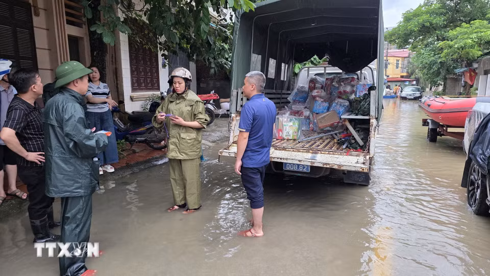 Lực lượng vũ trang phối hợp cùng chính quyền phường Tam Thanh tiến hành tiếp tế nhu yếu phẩm cho nhân dân vùng ngập lụt. (Ảnh: Quang Duy/TTXVN)