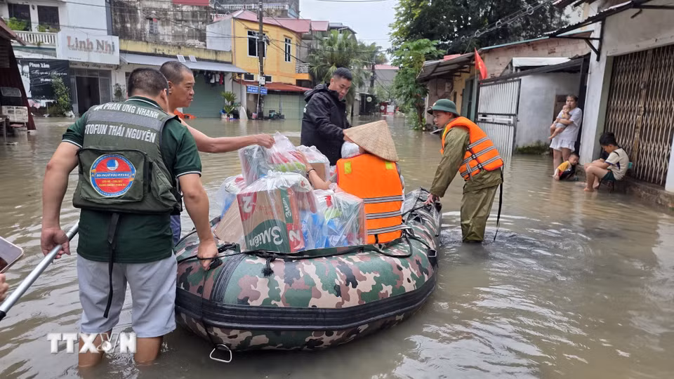Lực lượng chức năng hỗ trợ người dân phường Tam Thanh, tỉnh Lạng Sơn vận chuyển nhu yếu phẩm vào vùng ngập lụt.(Ảnh: Quang Duy/TTXVN)