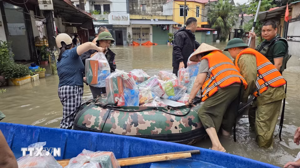 Lực lượng chức năng hỗ trợ tiếp tế nhu yếu phẩm và lương thực cho nhân dân vùng ngập lụt phường Tam Thanh, tỉnh Lạng Sơn. (Ảnh: Quang Duy/TTXVN)