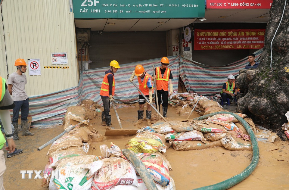 Công nhân đang nỗ lực khắc phục sự cố trước cổng số nhà 25F Cát Linh. (Ảnh: Thành Phương/TTXVN)