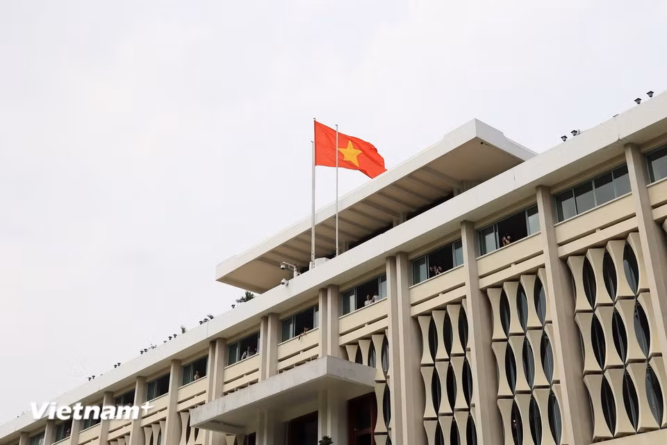 Lá cờ Tổ quốc tung bay trên nóc Dinh Độc Lập 50 năm sau ngày toàn thắng. (Ảnh: Hồng Đạt/Vietnam+)