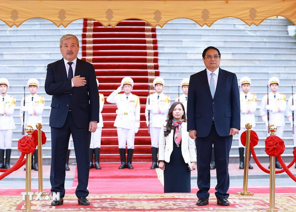 Thủ tướng Phạm Minh Chính và Thủ tướng Kyrgyzstan Adylbek Kasymaliev nghe quân nhạc cử Quốc thiều hai nước. (Ảnh: Dương Giang/TTXVN)