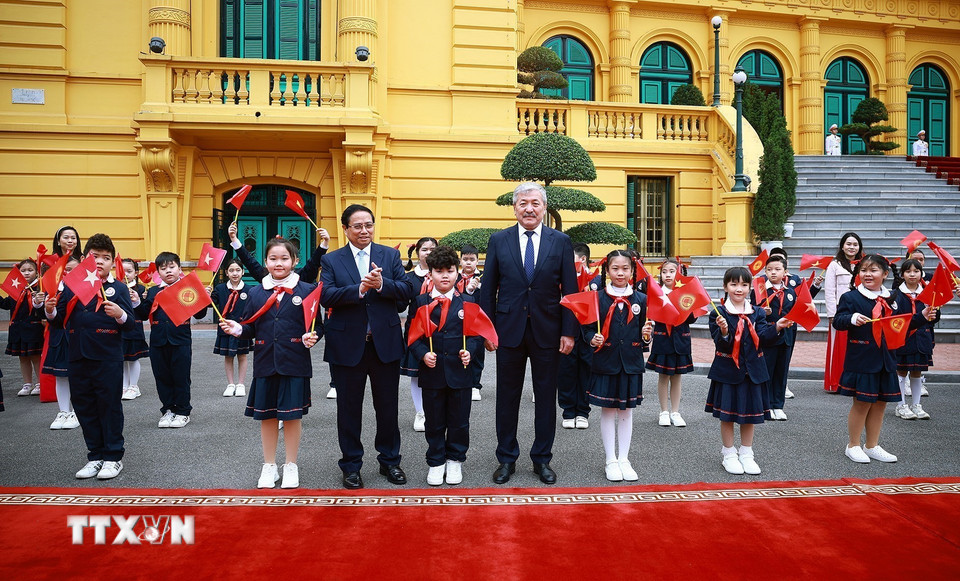 Thủ tướng Phạm Minh Chính và Thủ tướng Kyrgyzstan Adylbek Kasymaliev với thiếu nhi Thủ đô. (Ảnh: Dương Giang/TTXVN)