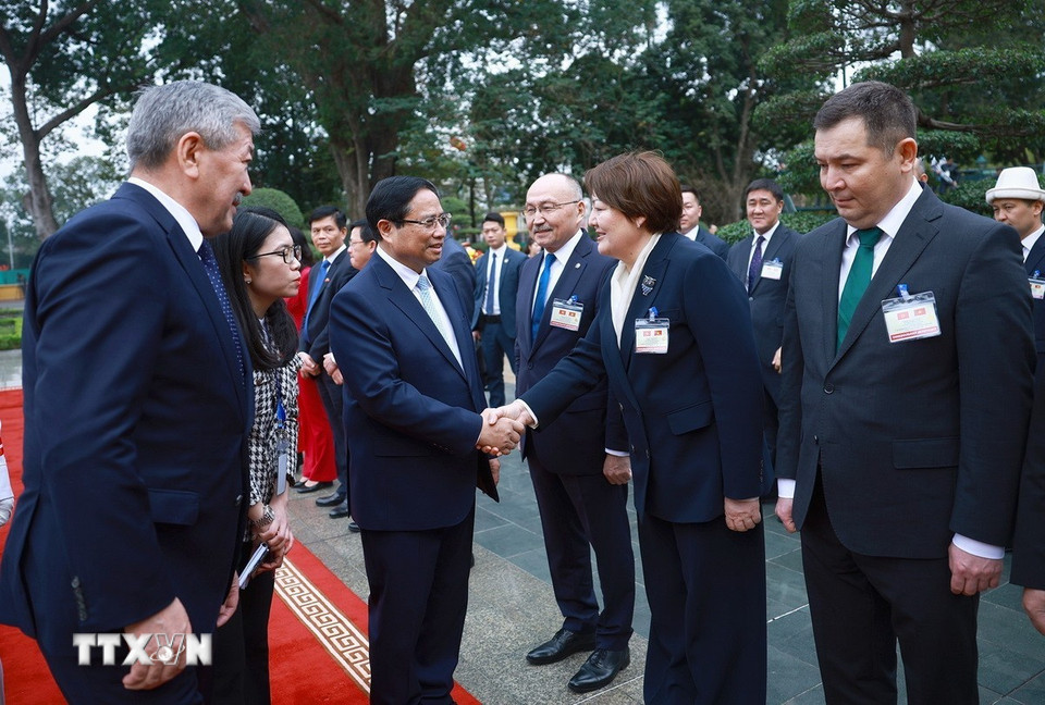 Thủ tướng Thủ tướng Kyrgyzstan Adylbek Kasymaliev giới thiệu với Thủ tướng Phạm Minh Chính thành viên Kyrgyzstan. (Ảnh: Dương Giang/TTXVN)
