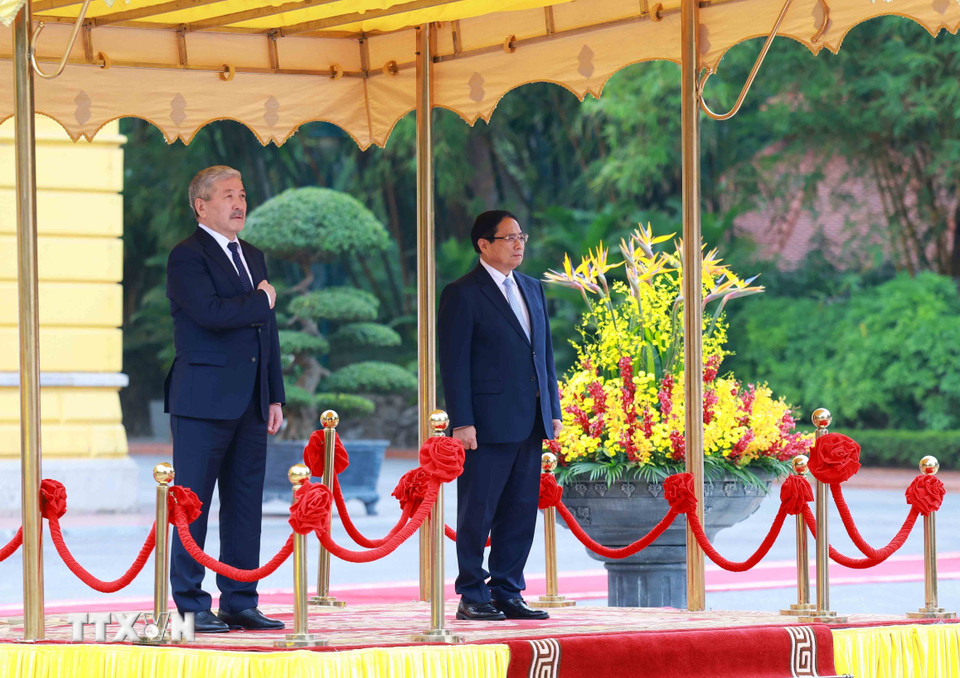 Thủ tướng Phạm Minh Chính và Thủ tướng Thủ tướng Kyrgyzstan Adylbek Kasymaliev nghe cử hành Quốc thiều hai nước. (Ảnh: Dương Giang/TTXVN)