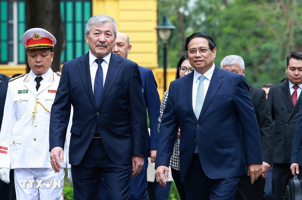 Thủ tướng Phạm Minh Chính và Thủ tướng Thủ tướng Kyrgyzstan Adylbek Kasymaliev tại lễ đón. (Ảnh: Dương Giang/TTXVN)