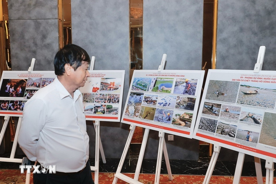 Thành viên Hội đồng chung khảo Giải báo chí Quốc gia xem, thảo luận về các tác phẩm ảnh lọt vào vòng chung khảo. (Ảnh: Minh Quyết/TTXVN)