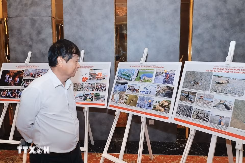 Thành viên Hội đồng chung khảo Giải báo chí Quốc gia xem, thảo luận về các tác phẩm ảnh lọt vào vòng chung khảo. (Ảnh: Minh Quyết/TTXVN)