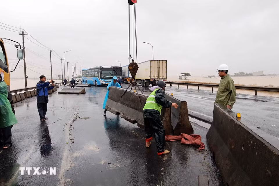 Nỗ lực khắc phục dải phân cách cứng bị trôi dạt trên Quốc lộ 1A. (Ảnh: Đỗ Trưởng/TTXVN)
