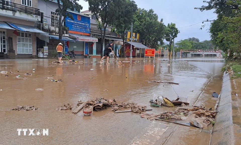 Người dân sống ở bờ Nam sông Hương, thành phố Huế dọn bùn, rác thải khi nước lũ rút sáng 29/10. (Ảnh: Nguyên Lý/TTXVN)