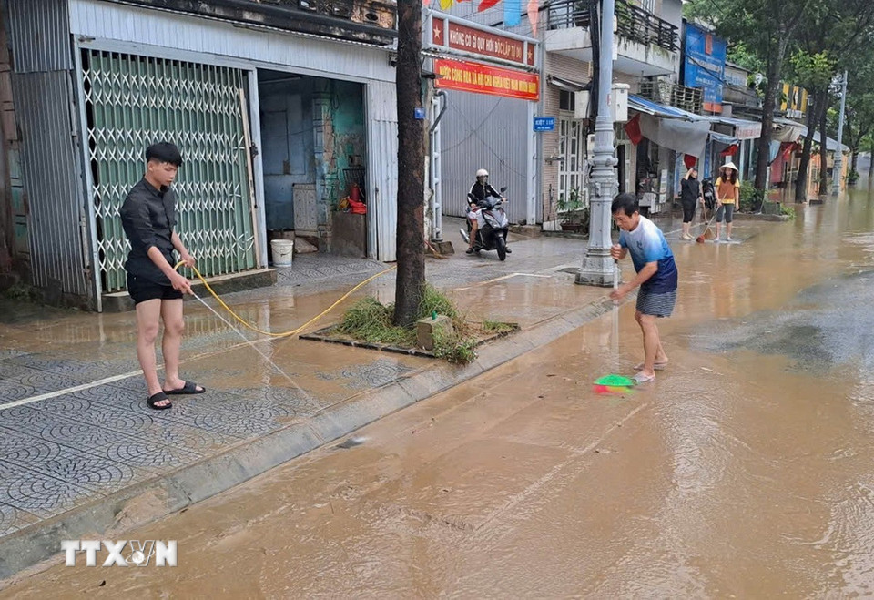 Người dân sống ở bờ Nam sông Hương, thành phố Huế dọn bùn, rác thải khi nước lũ rút sáng 29/10. (Ảnh: Nguyên Lý/TTXVN)