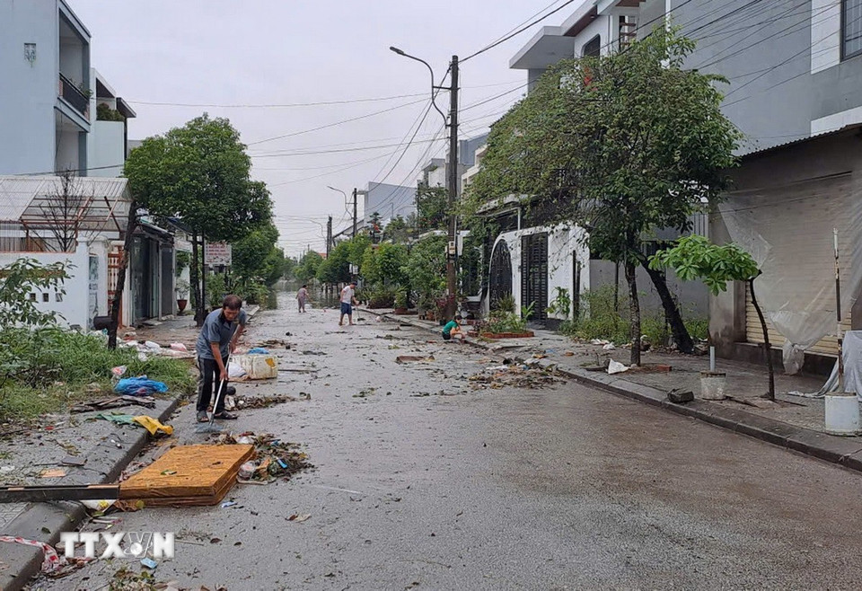 Người dân sống ở Khu đô thị Bàu Vá, phường Thủy Xuân, thành phố Huế dọn bùn, rác thải khi nước lũ rút sáng 29/10. (Ảnh: Nguyên Lý/TTXVN)