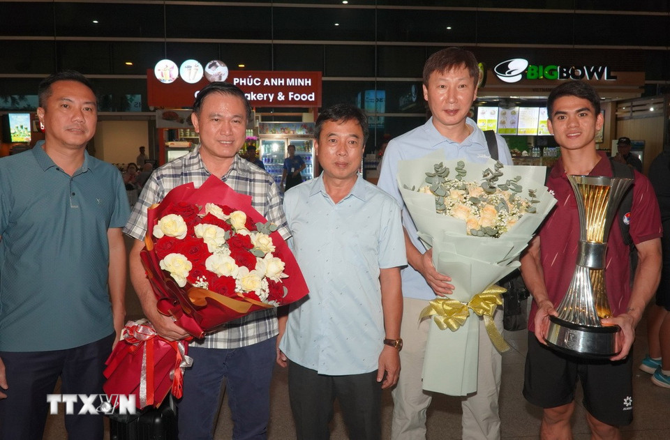 Ban lãnh đạo đội tuyển nhận hoa chúc mừng của các cổ động viên. (Ảnh: Trung Tuyến/TTXVN)