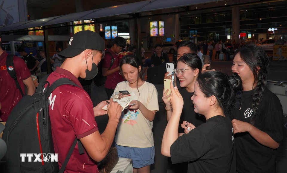 Các cầu thủ ký tên tặng người hâm mộ. (Ảnh: Trung Tuyến/TTXVN)