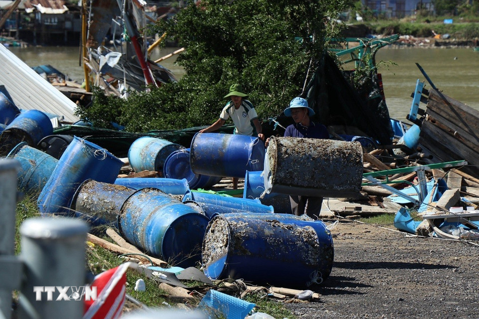 Người dân dọn dẹp lồng, bè sau cơn bão. (Ảnh: Tuấn Anh/TTXVN)
