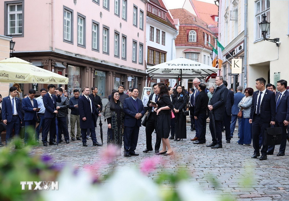 Thủ tướng Phạm Minh Chính cùng Phu nhân tham quan, nghe giới thiệu về lịch sử khu phố cổ Tallinn. (Ảnh: Dương Giang/TTXVN)