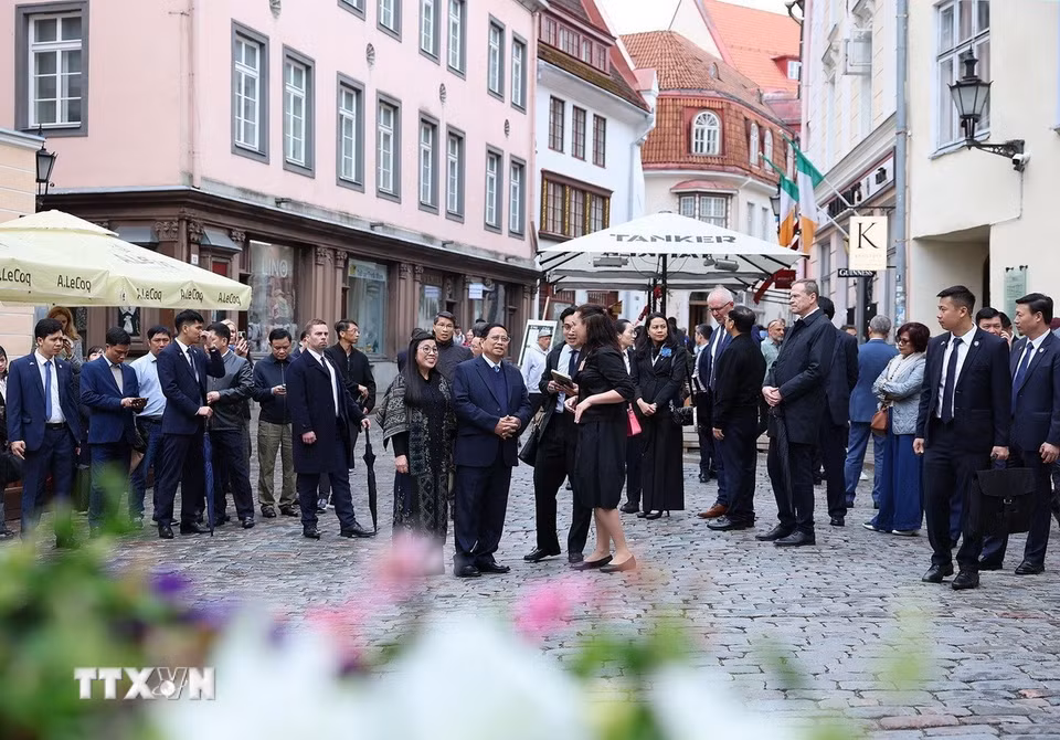Thủ tướng Phạm Minh Chính cùng Phu nhân tham quan, nghe giới thiệu về lịch sử khu phố cổ Tallinn. (Ảnh: Dương Giang/TTXVN)