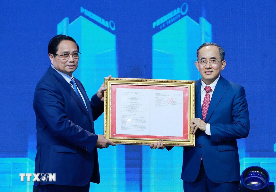 Thủ tướng Phạm Minh Chính trao Quyết định chuyển mô hình thành Đại học Phenikaa cho đại diện lãnh đạo Đại học Phenikaa. (Ảnh: Dương Giang/TTXVN)