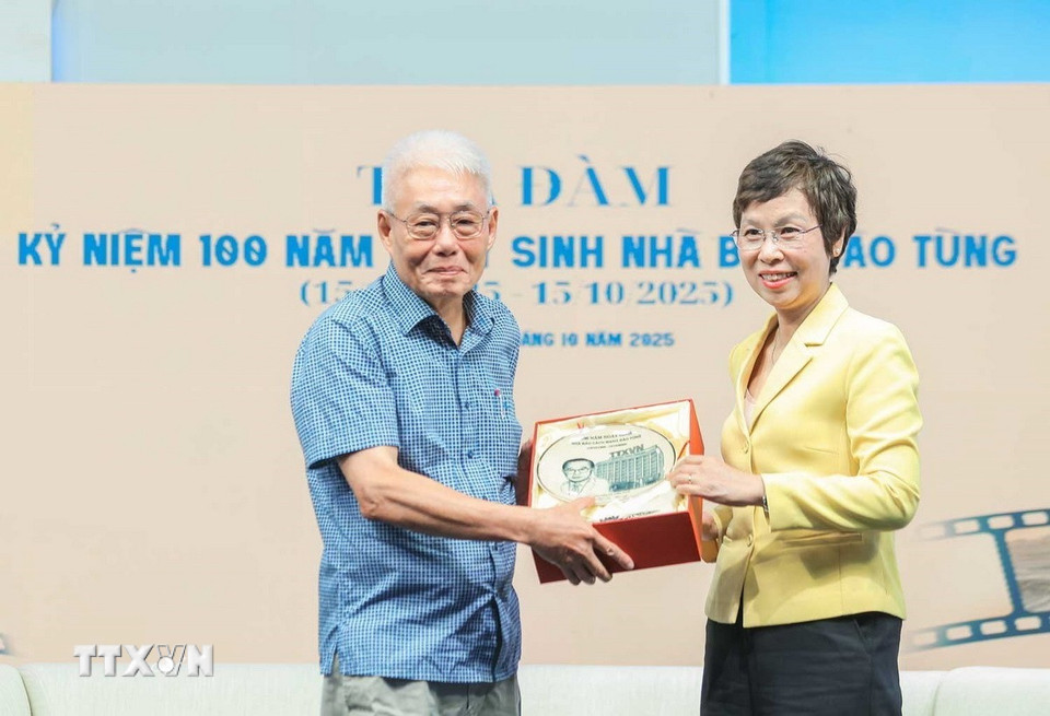 Tổng Giám đốc TTXVN Vũ Việt Trang tặng quà cho đại diện gia đình Nhà báo Đào Tùng. (Ảnh: Hoàng Hiếu/TTXVN)