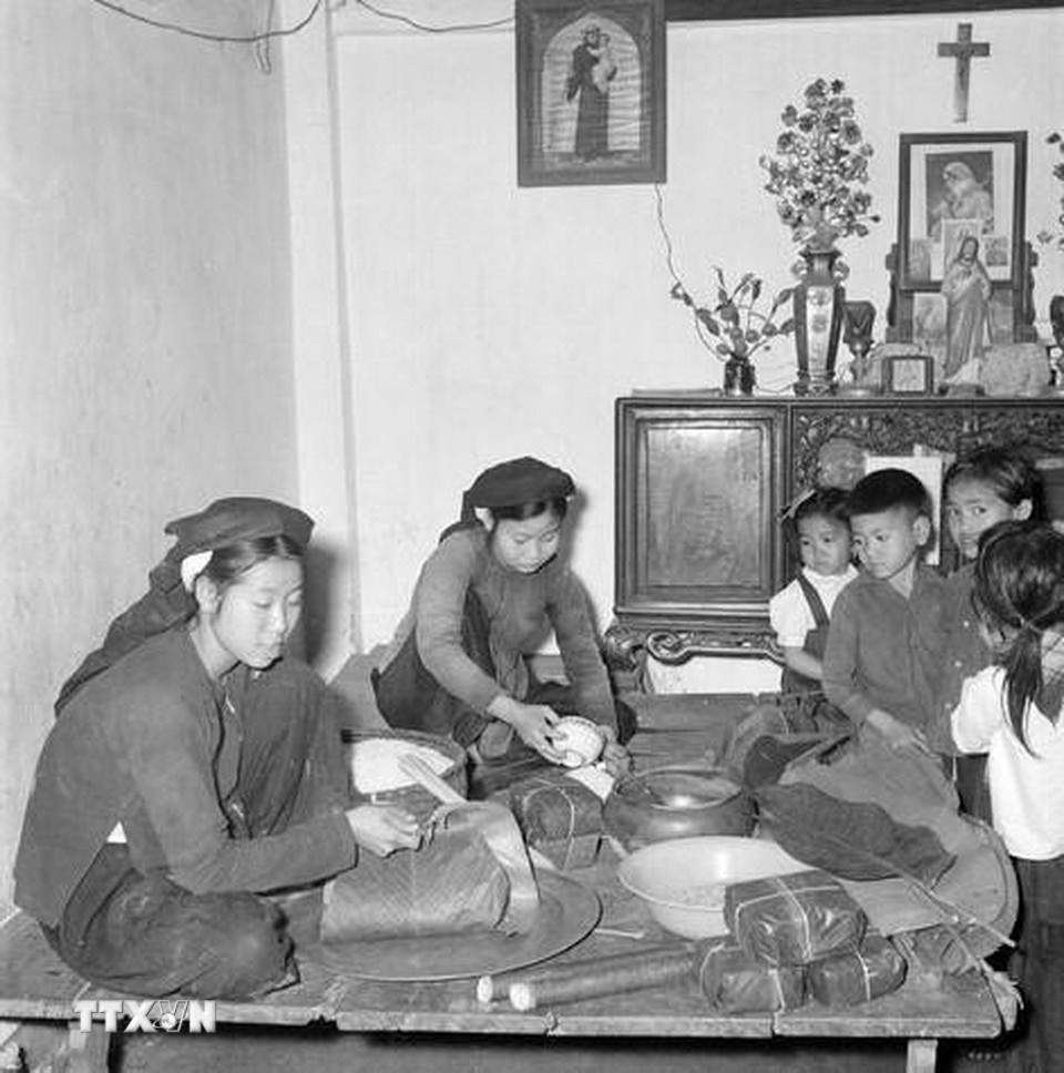 Một gia đình công giáo ở ngoại thành Hà Nội gói bánh chưng Tết. (Ảnh: TTXVN)