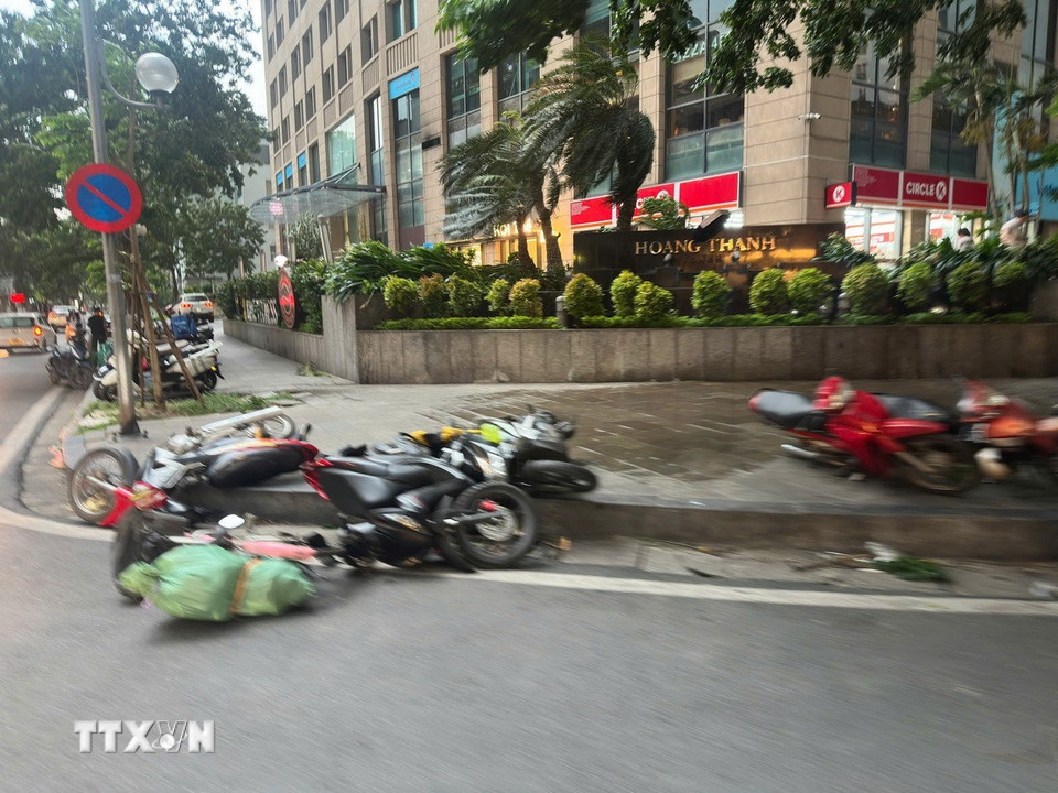 Nhiều phương tiện giao thông bị quật đổ do gió mạnh. (Ảnh: Phạm Tuấn Anh/TTXVN)