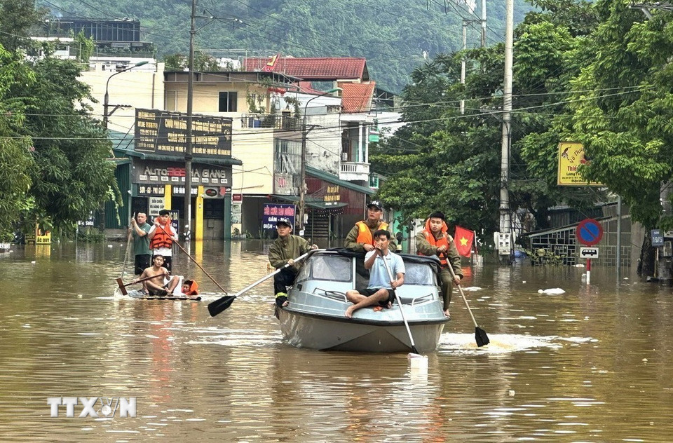 Cán bộ, chiến sỹ Công an tỉnh Tuyên Quang hỗ trợ người dân phường Hà Giang 1 sơ tán khu vực ngập lụt. (Ảnh: Minh Tâm/TTXVN)