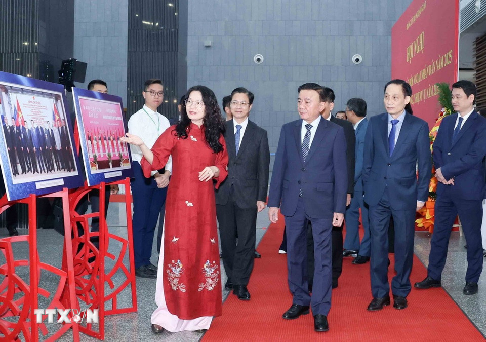 Ông Trần Cẩm Tú, Ủy viên Bộ Chính trị, Bí thư Trung ương Đảng, Thường trực Ban Bí thư, với các đại biểu tham quan trưng bày hình ảnh nổi bật về công tác đối ngoại nhân dân năm 2025. (Ảnh: An Đăng/TTXVN)