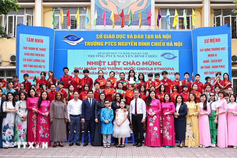 Bà Lê Thị Bích Trân, Phu nhân Thủ tướng Phạm Minh Chính, và bà Zinash Tayachew, Phu nhân Thủ tướng Ethiopia, chụp ảnh với các thầy cô giáo và học sinh. (Ảnh: Minh Đức/TTXVN)