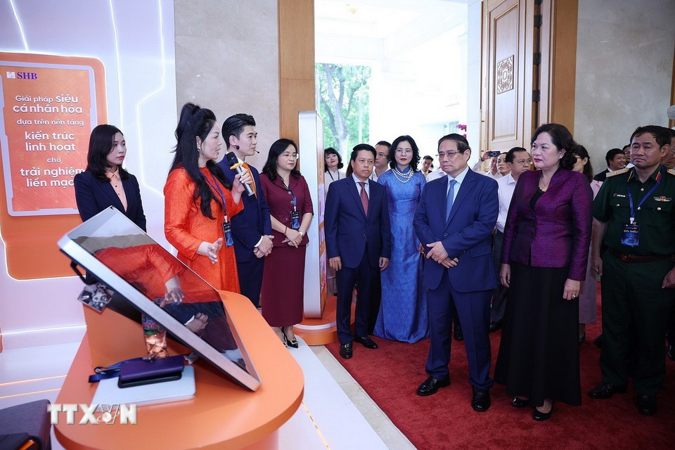 Thủ tướng Phạm Minh Chính tham quan trưng bày sản phẩm dịch vụ, ứng dụng chuyển đổi số trong hoạt động ngân hàng. (Ảnh: Dương Giang/TTXVN)
