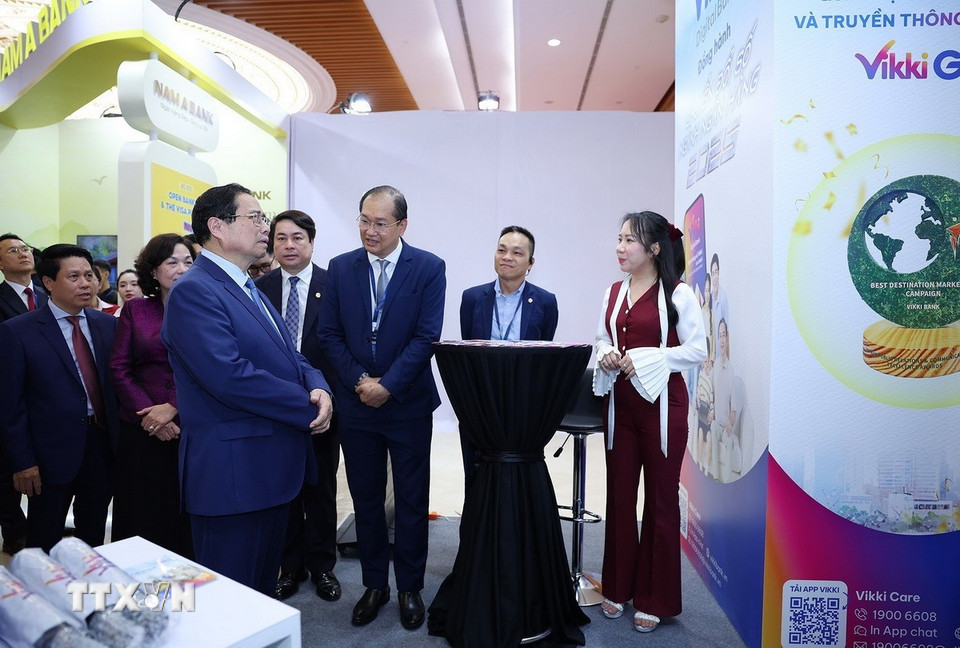 Thủ tướng Phạm Minh Chính tham quan trưng bày sản phẩm dịch vụ, ứng dụng chuyển đổi số trong hoạt động ngân hàng. (Ảnh: Dương Giang/TTXVN)