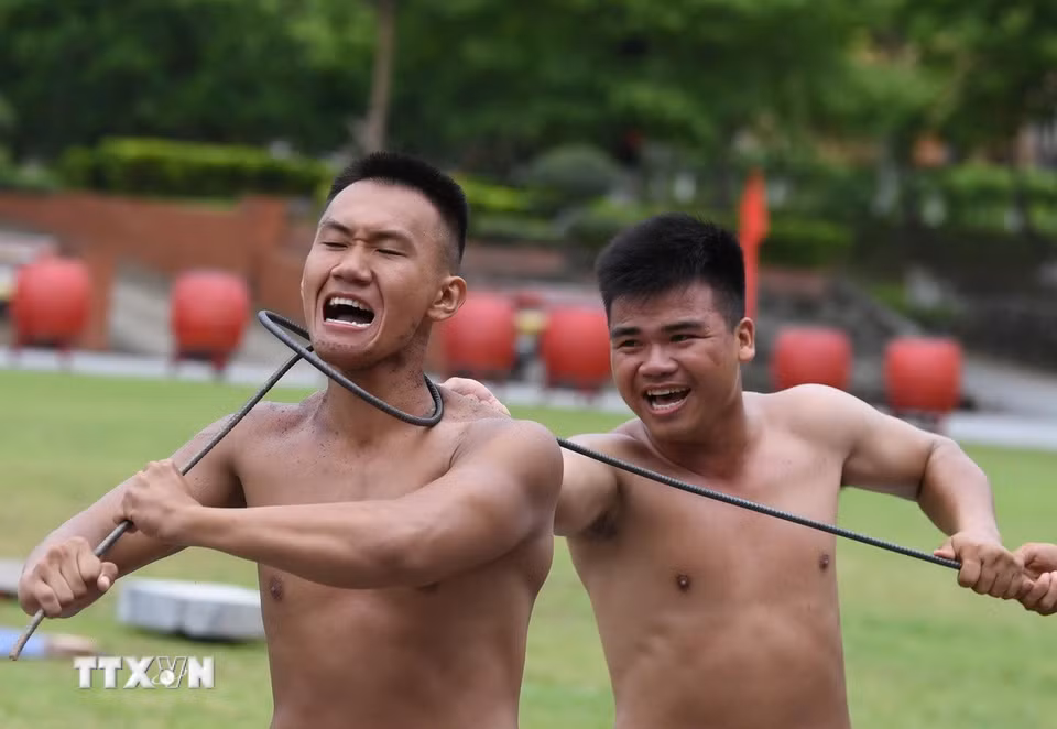 Biểu diễn công phá cuốn thép quanh cổ. (Ảnh: Trọng Đức/TTXVN)