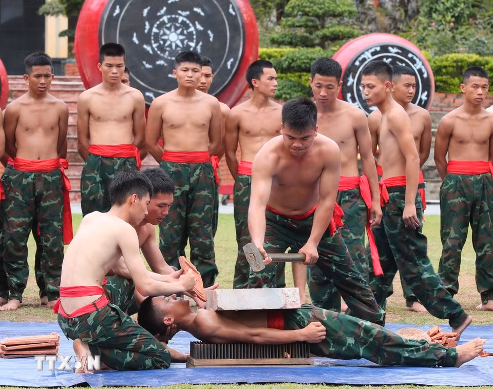 Biểu diễn công phá đập đá trên người nằm trên bàn chông của chiến sỹ năm thứ 2. (Ảnh: Trọng Đức/TTXVN)