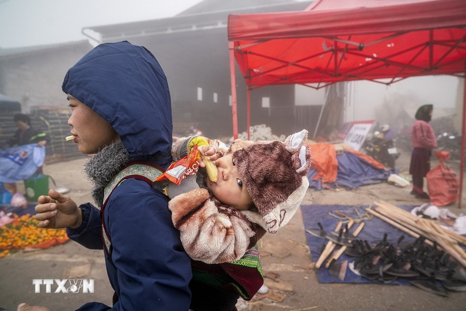 Em nhỏ được mẹ địu trên lưng đi chợ phiên Phố Cáo, huyện Đồng Văn, Hà Giang. (Ảnh: Khánh Hòa/TTXVN)